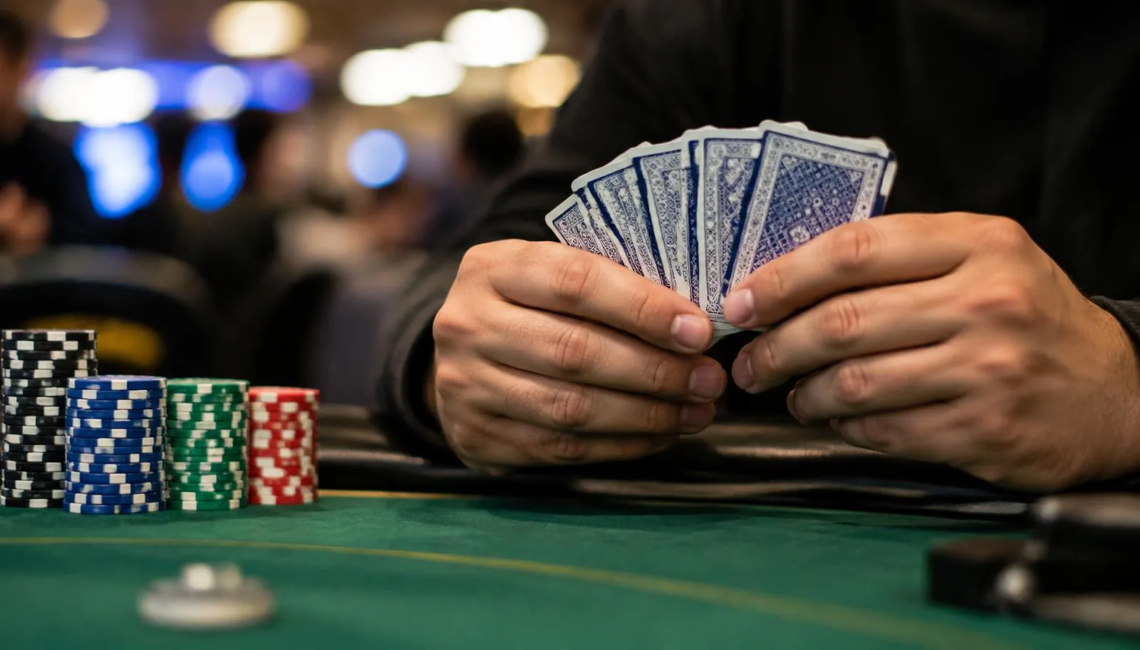 Player holding five Omaha cards at a live poker table